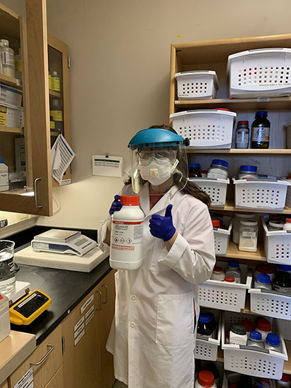 Emma in a lab coat and mask.