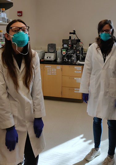 Two students social distancing with masks on.