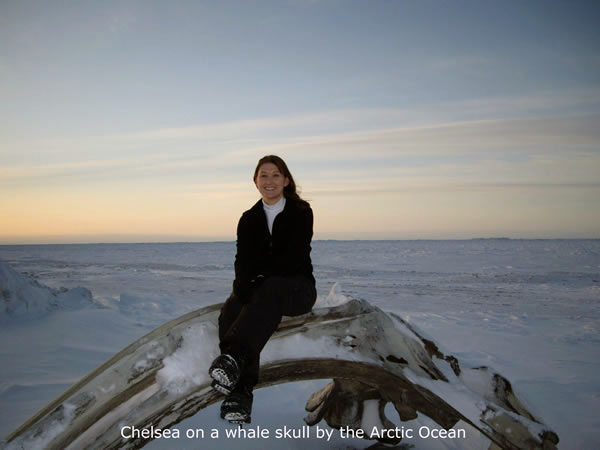 Chelsea sitting on a whale skull by the Artic Ocean