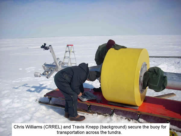 Chris Williams (CRREL) and Travis Knapp (background) secure the buoy for transportation across the tundra.